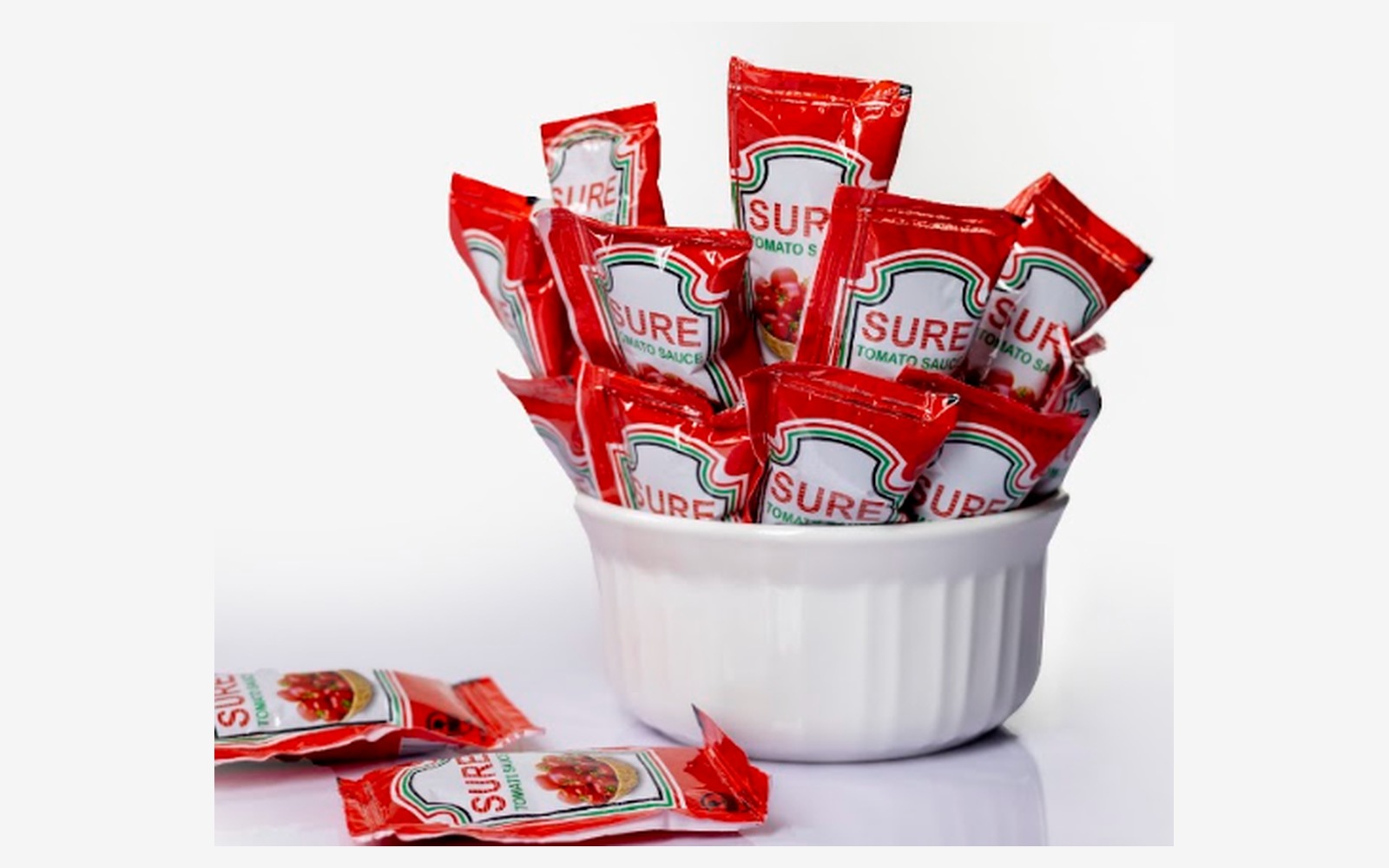 Sure Tomato Sauce single-serve sachets in a white serving bowl